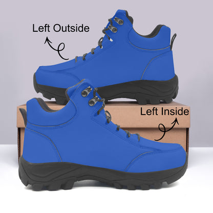 Blue hiking boots with black soles on a gray background