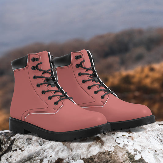 Pink boots with black soles on a rock with a blurred natural background