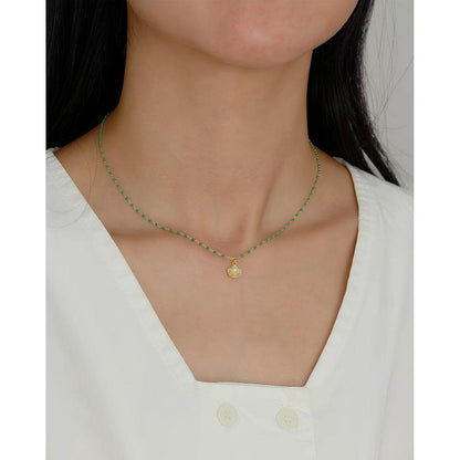 necklace with round natural pearl shell pendant, green epoxy resin, and 925 sterling silver chain, displayed on neck