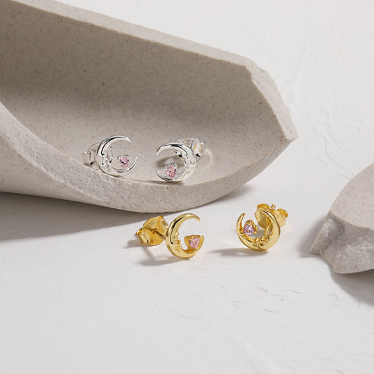 Gold and silver Crescent Moon earrings with pink gemstones on a light background