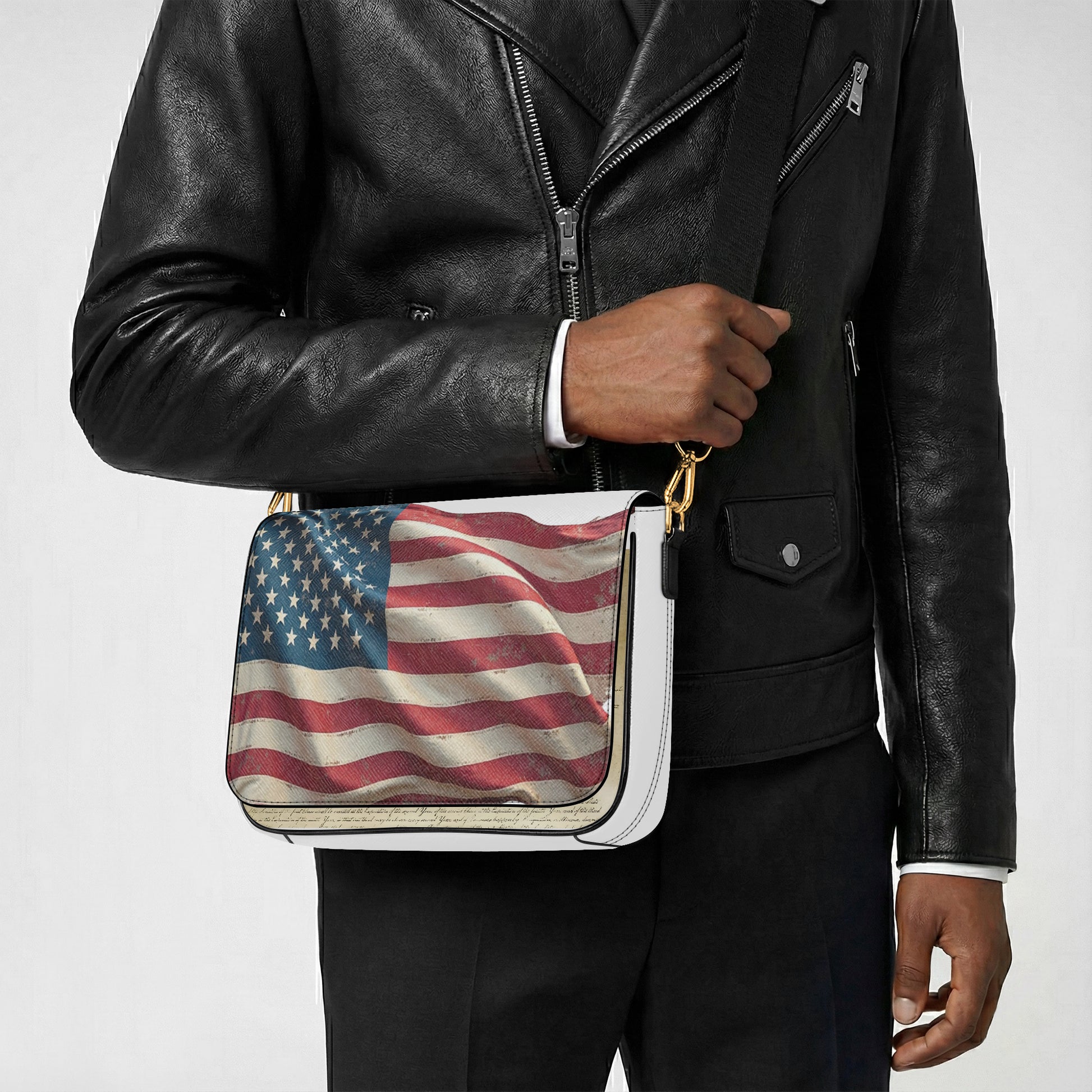 Person wearing a black leather jacket holding a bag with an American flag design.