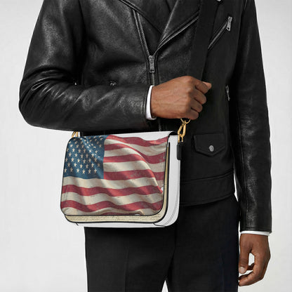 Person wearing a black leather jacket holding a bag with an American flag design.
