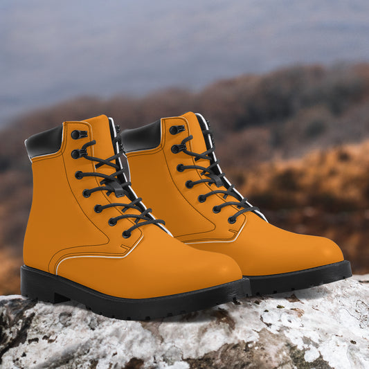 Pair of orange hiking boots with black soles on a rock with a blurred natural background